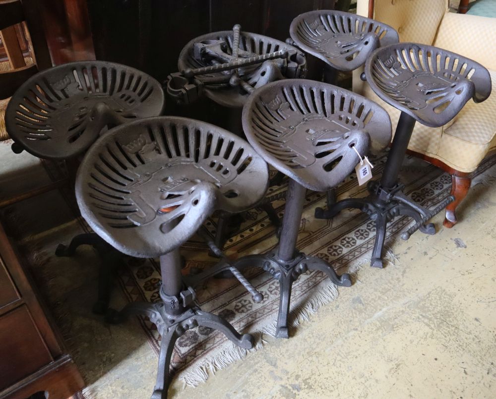 A set of six painted cast metal tractor seat stools, width 37cm depth 30cm height 64cm